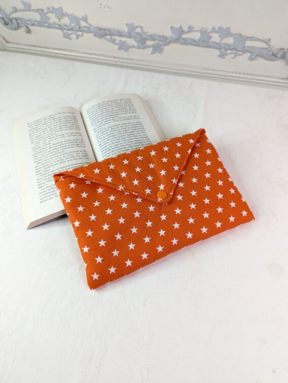 Pochette ,protège livre format poche ,rembourré ,fond orange étoiles blanches