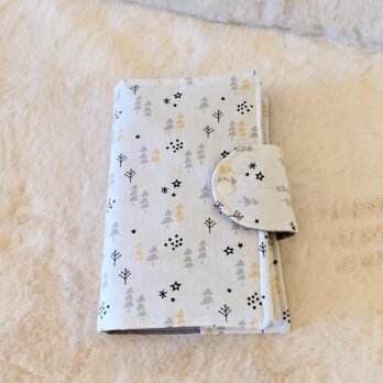 Protège livre format poche ,  avec un rabat sur le coté , sapins dorés et gris