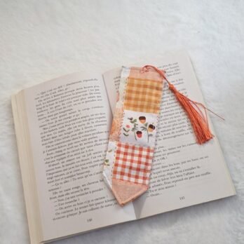 Marque page souple  , en coton , avec pompon , motif patchwork ton orange